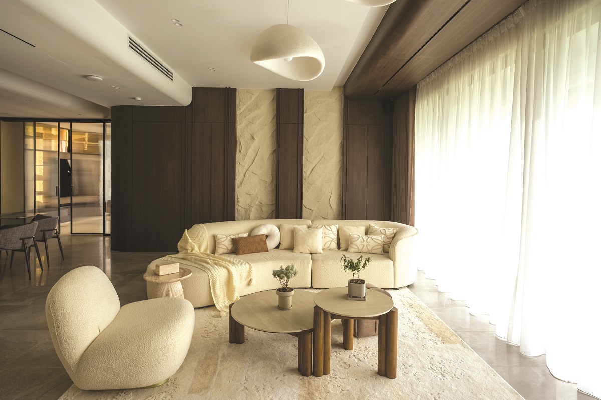 Living room: Curved cabinetry, layered textures, and soft lighting create a calm, open space. (Photos by Z Han/Design Bliss)