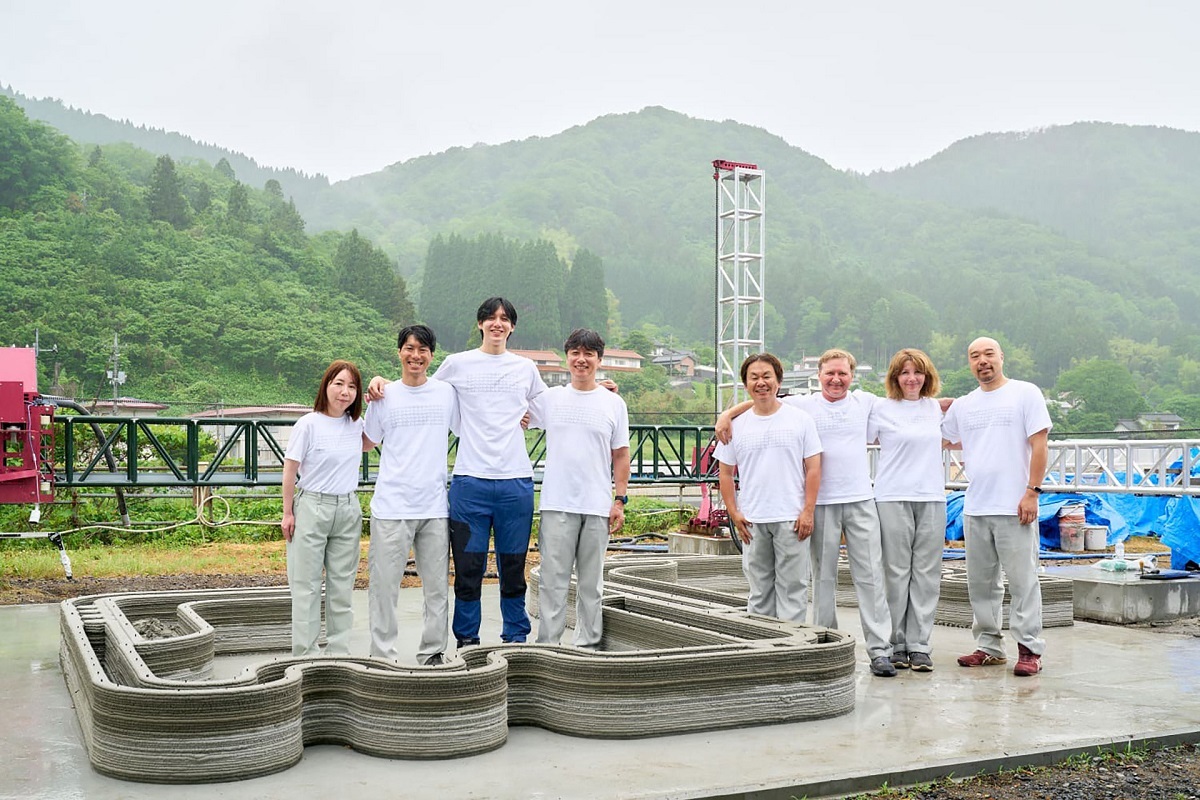 Members of the V3D Asia and Nuvah team at a 3D construction-printing site, with printed concrete wall sections and the gantry system in the background. (Photo courtesy of V3D Asia/Nuvah)
