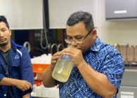 Selangor Menteri Besar Datuk Seri Amirudin Shari examining a water sample from the polluted area in Sungai Selangor during a visit to a water treatment plant at Sungai Selangor on Tuesday night.